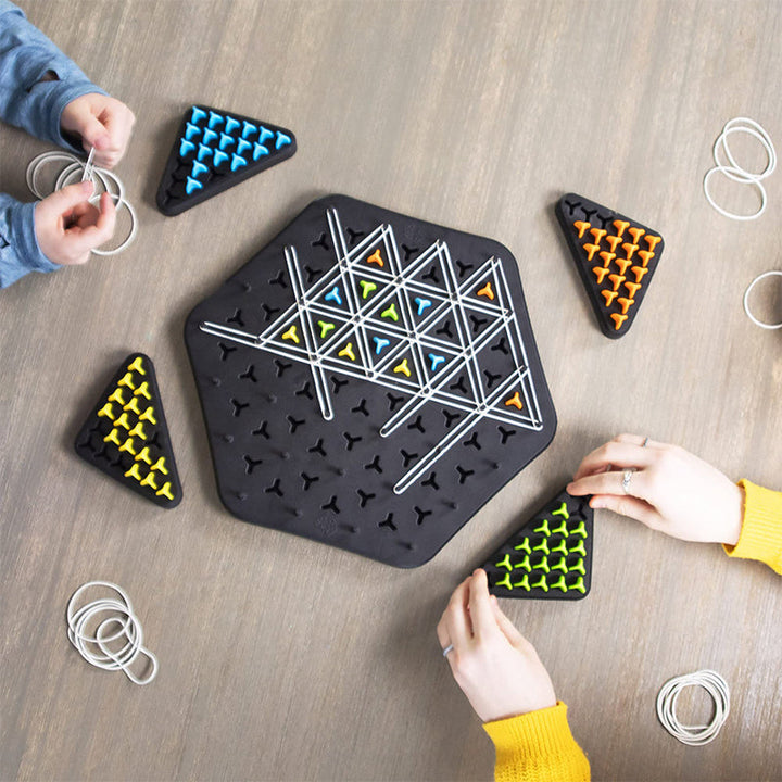Amis riant autour du jeu LinkLogic, partageant un moment de divertissement stratégique et coopératif, parfait pour soirée.
