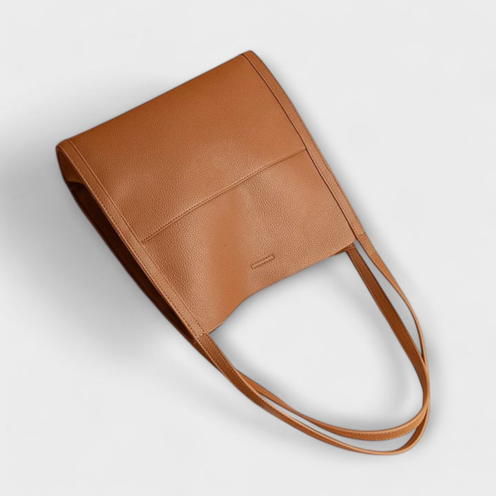 Sac à main en cuir fait main posé. Met en valeur son design intemporel, sa qualité et son élégance féminine.