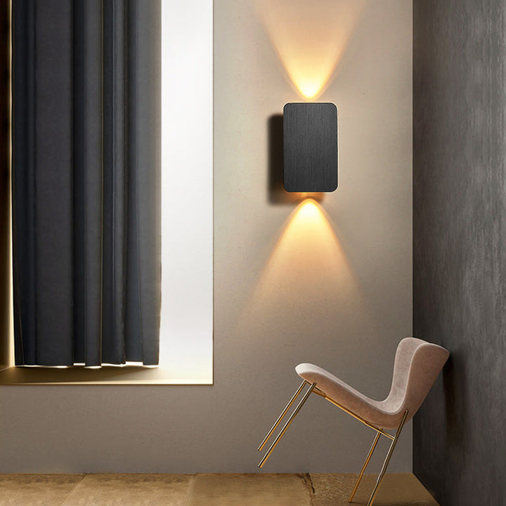 Éclairage intérieur LED rectangulaire en métal, crée une ambiance chaleureuse dans salon ou chambre avec lumière douce.