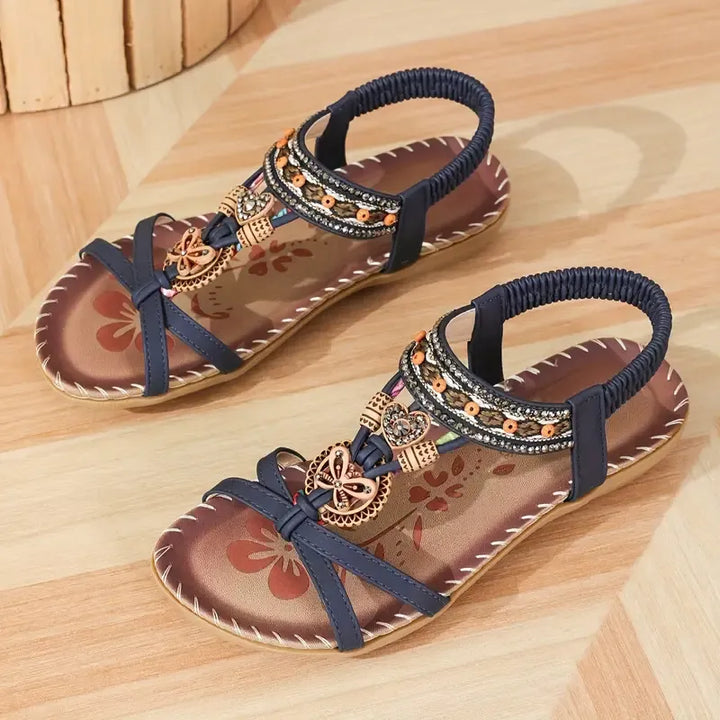 Femme portant des sandales plates élégantes à strass. Chaussures d'été confortables, style bohème chic pour soirée.