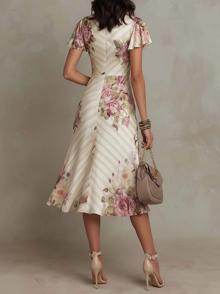 Robe femme midi fleurie style rétro chic, encolure cache-cœur. Parfaite pour occasion spéciale ou soirée d'été élégante.