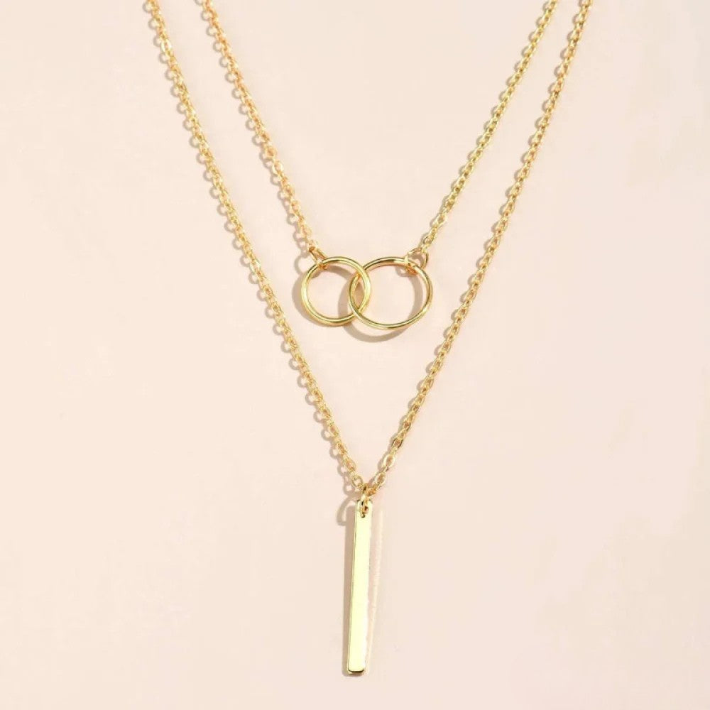 Pendentif femme doré style rétro avec deux cercles entrelacés, collier chic et tendance.
