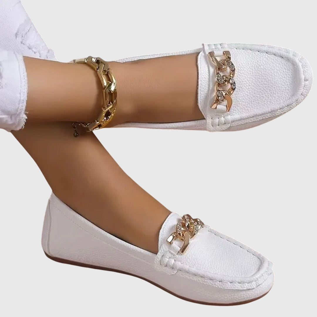 Mocassins femme noirs élégants avec chaîne dorée, bout rond. Parfaits pour le bureau ou look chic décontracté.