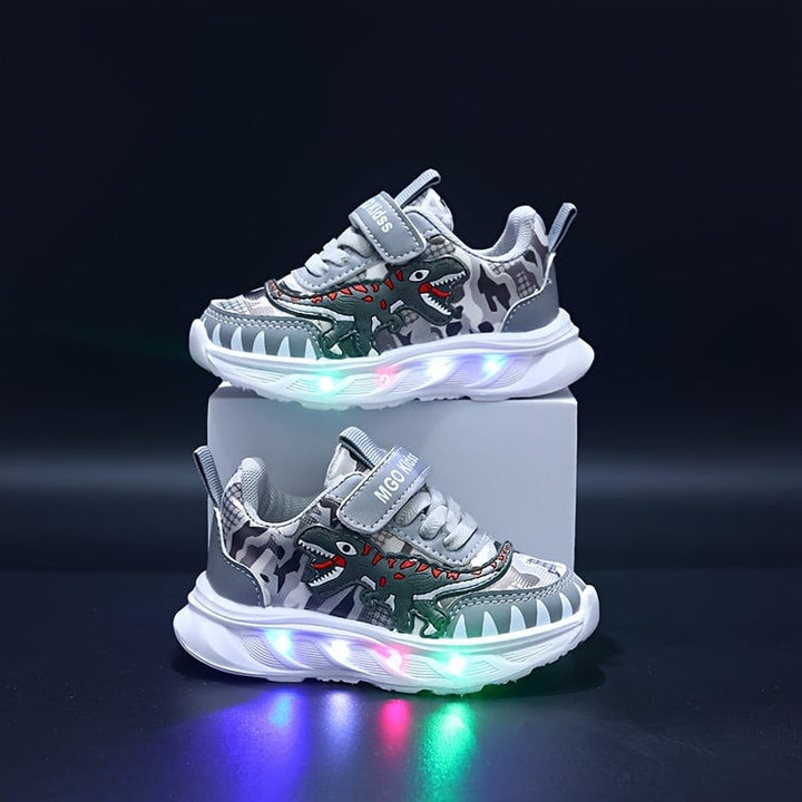 Motifs dinosaures vifs sur ces chaussures de sport LED pour garçons. Baskets enfants colorées et lumineuses.