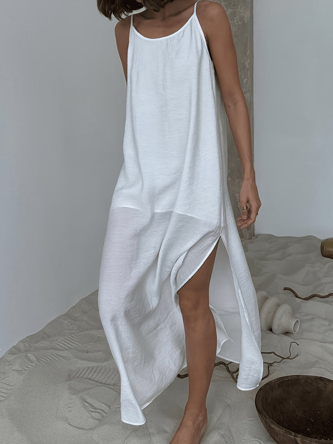 Robe d'été femme blanche, coupe longue et minimaliste, idéale pour un style décontracté et élégant.