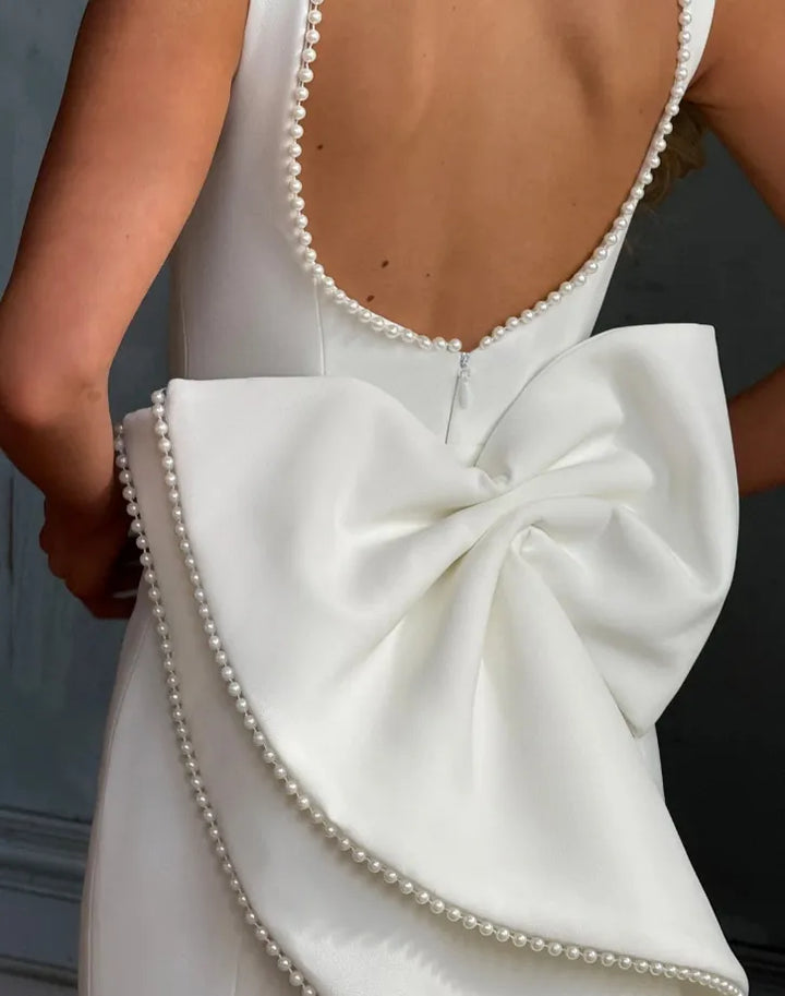 Robe femme élégante et glamour pour fête ou cérémonie, couleur blanche, encolure perlée luxueuse, coupe longue.