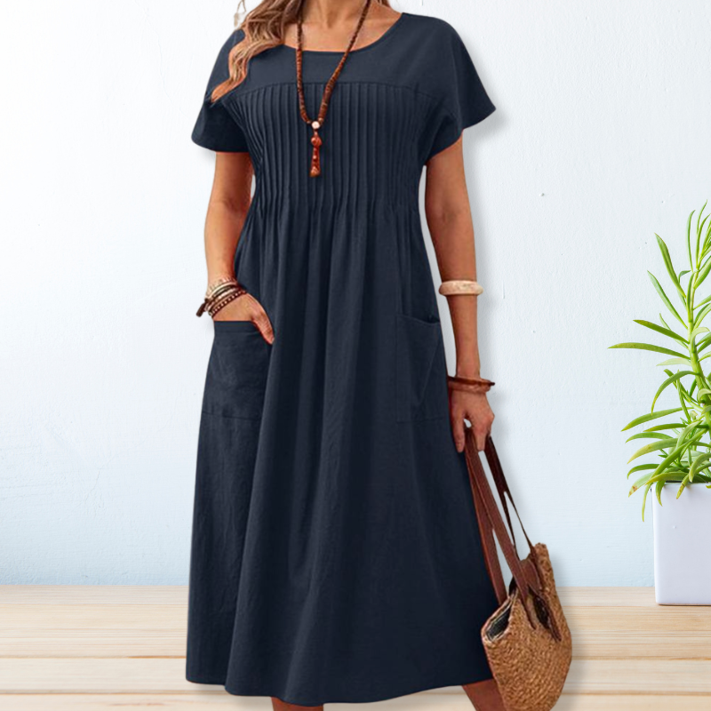Robe femme décontractée ample, coupe midi. Col rond classique et poches pour un style chic et confortable.