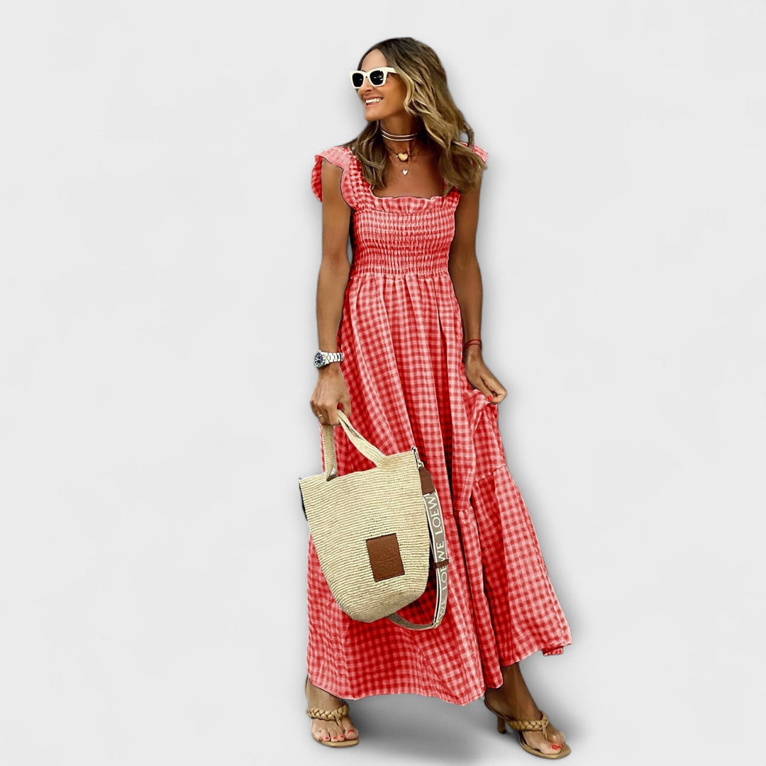 Femme portant une robe longue à carreaux avec des manches volants, idéale pour un style printanier décontracté.