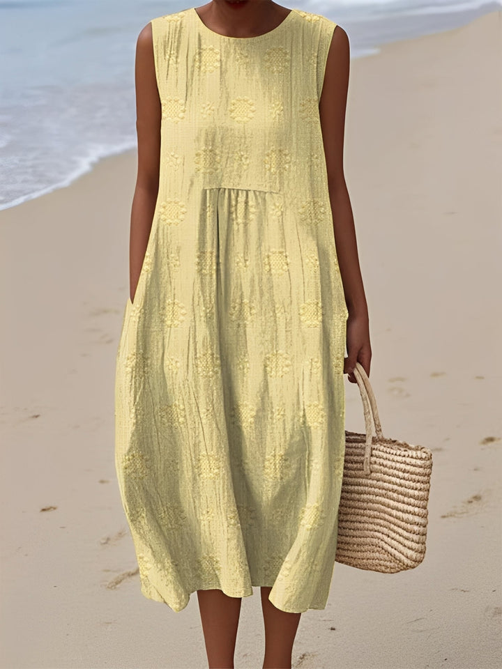 Robe midi femme sans manches et à motifs, avec poches discrètes. Confort moderne pour vos journées d'été.