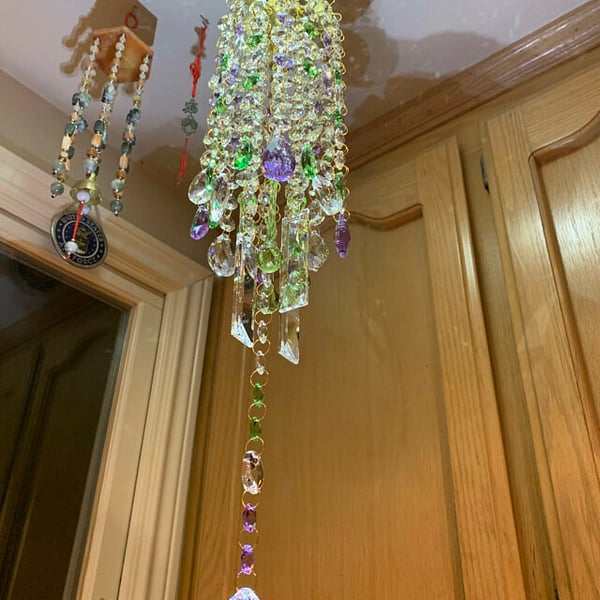 Détail rapproché d'un carillon en cristal, perles polies et reflets lumineux pour décoration.