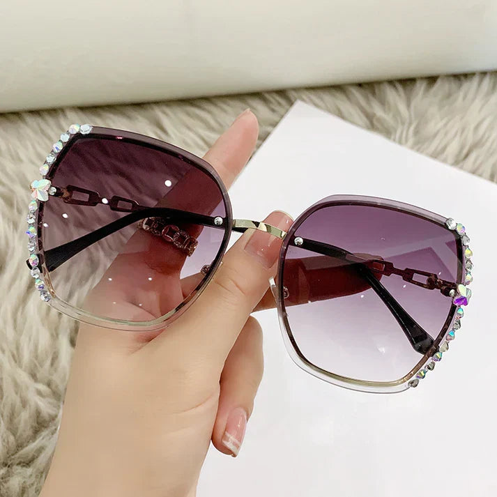 Design moderne: lunettes de soleil femme sans monture, cristaux subtils, verres dégradés élégants.