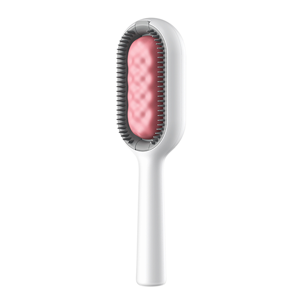 Main tenant le peigne de soin hydratant pour animaux domestiques. Brosse ergonomique 2-en-1 pour chat et chien.