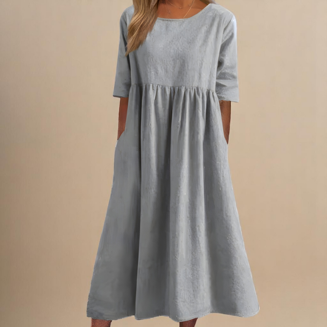 Femme profitant du confort d'une robe longue ample en coton décontractée, chic pour l'été.