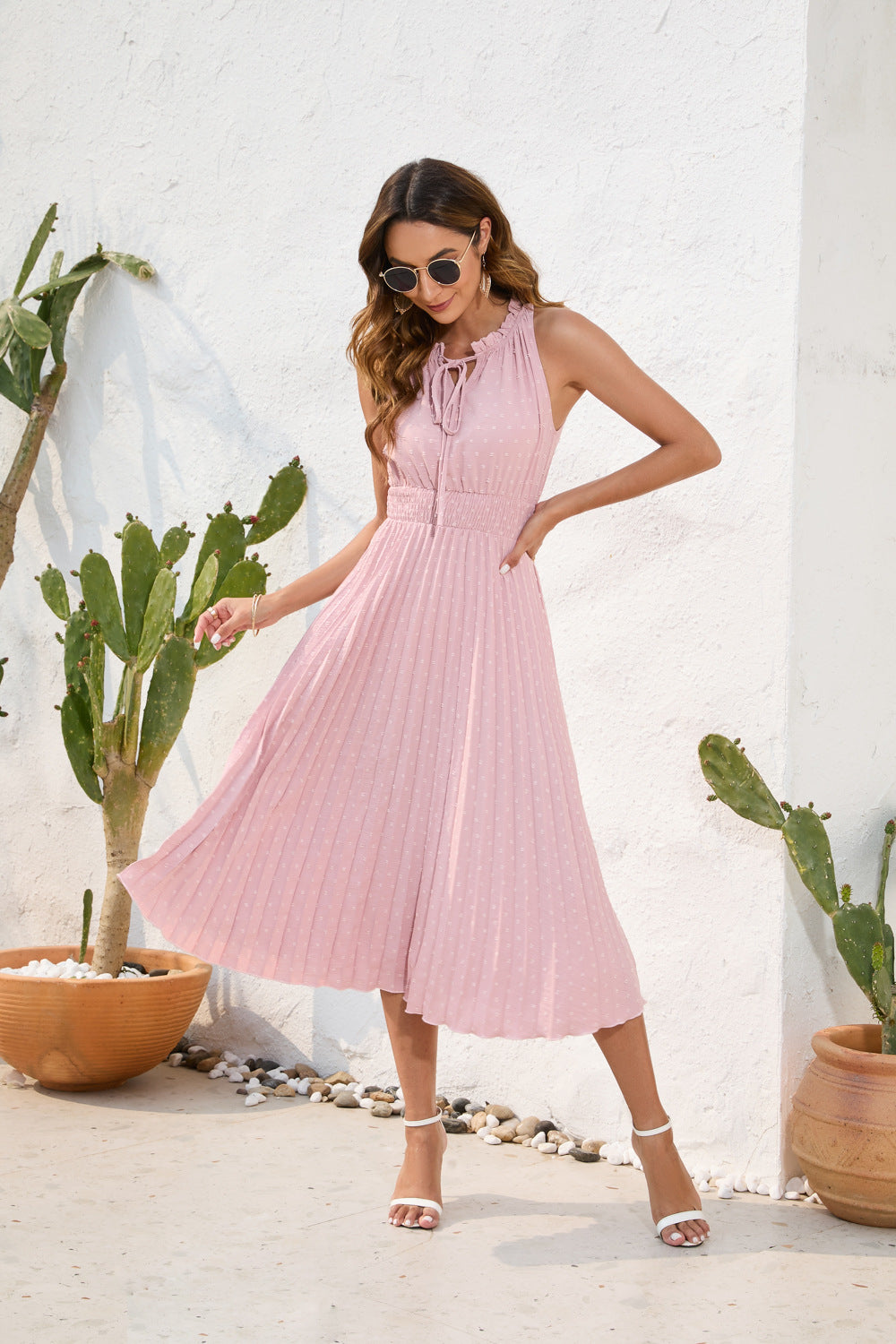 Robe midi femme élégante, plissée et fluide, avec col neckholder sans manches, idéale pour l'été et les soirées.