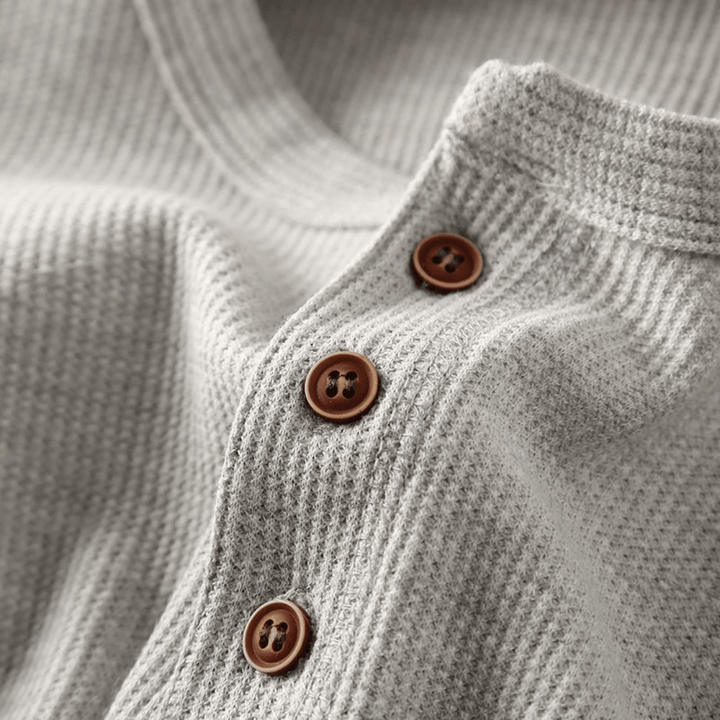 Texture riche et maille confortable du pull Henley pour homme. Idéal pour une tenue polyvalente et élégante.