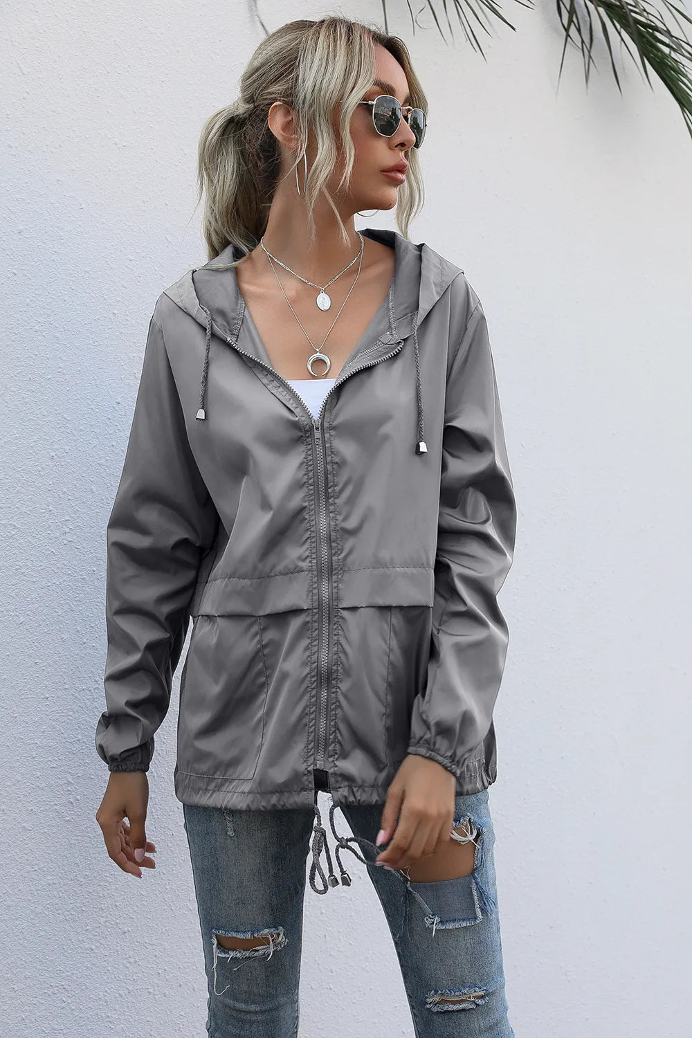 Femme active en veste imperméable et légère, prête pour le sport ou une balade urbaine. Style et protection.