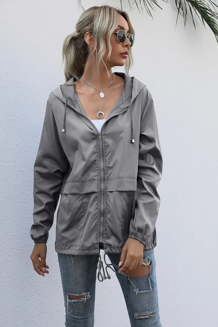 Femme active en veste imperméable et légère, prête pour le sport ou une balade urbaine. Style et protection.
