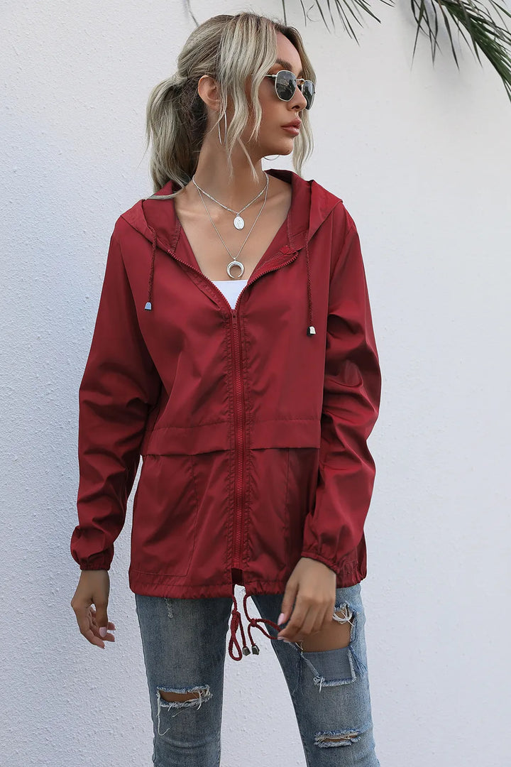 Femme élégante portant une veste imperméable légère pour le printemps, idéale pour la ville et les voyages.