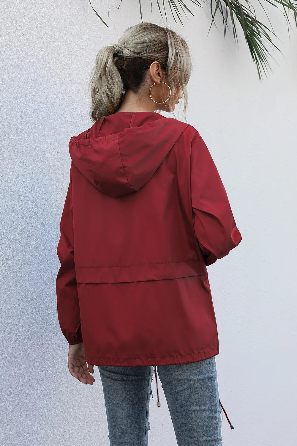 Vue arrière d'une veste coupe-vent femme, parfaite pour la randonnée et les activités extérieures. Protection optimale.