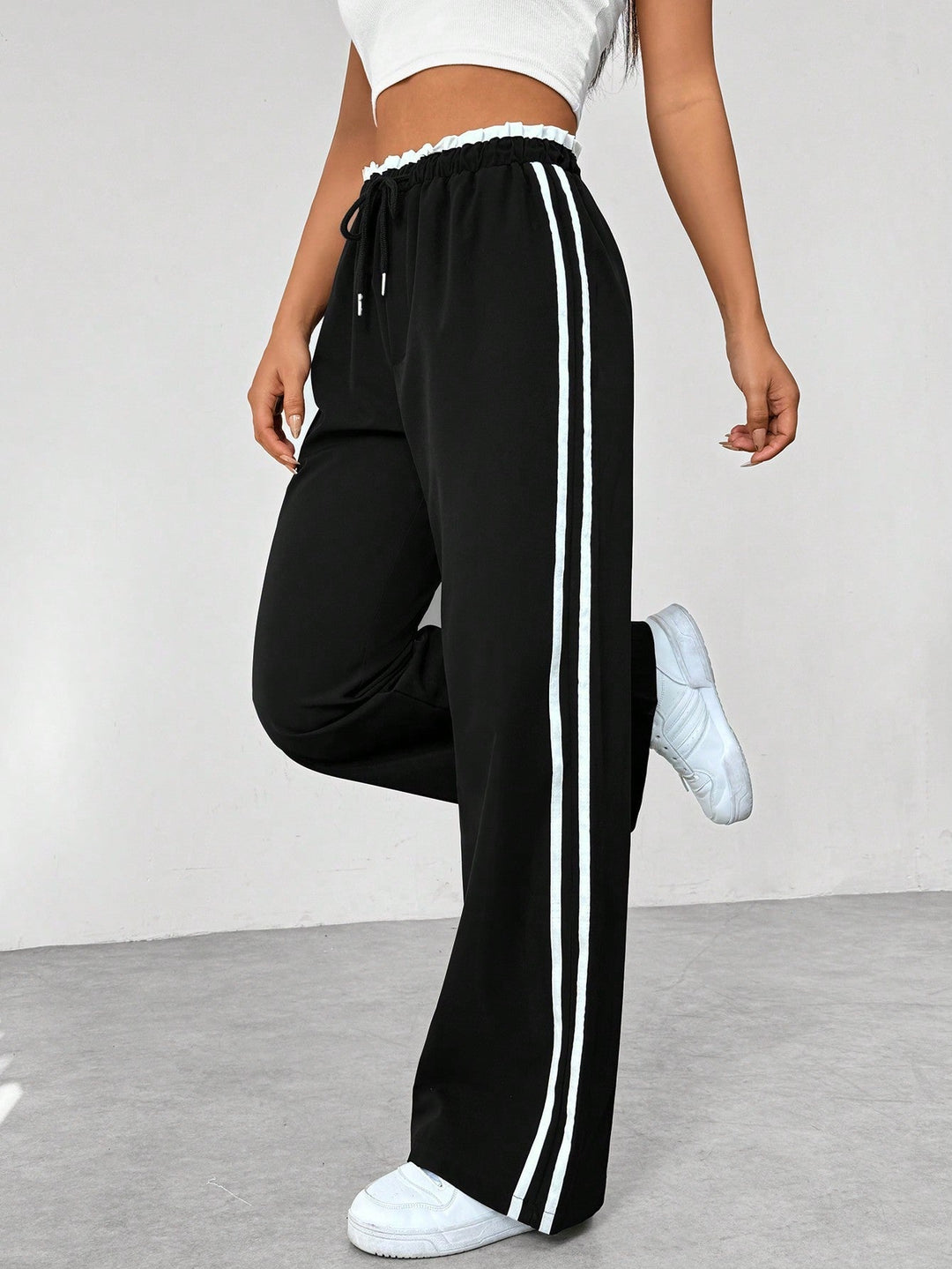 Pantalon ample sportif femme tendance, noir, jambe large, confortable pour athleisure et mode urbaine décontractée.