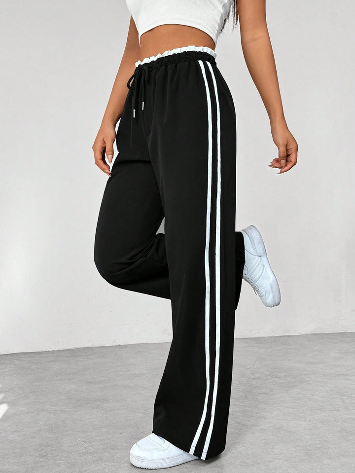 Pantalon ample sportif femme tendance, noir, jambe large, confortable pour athleisure et mode urbaine décontractée.