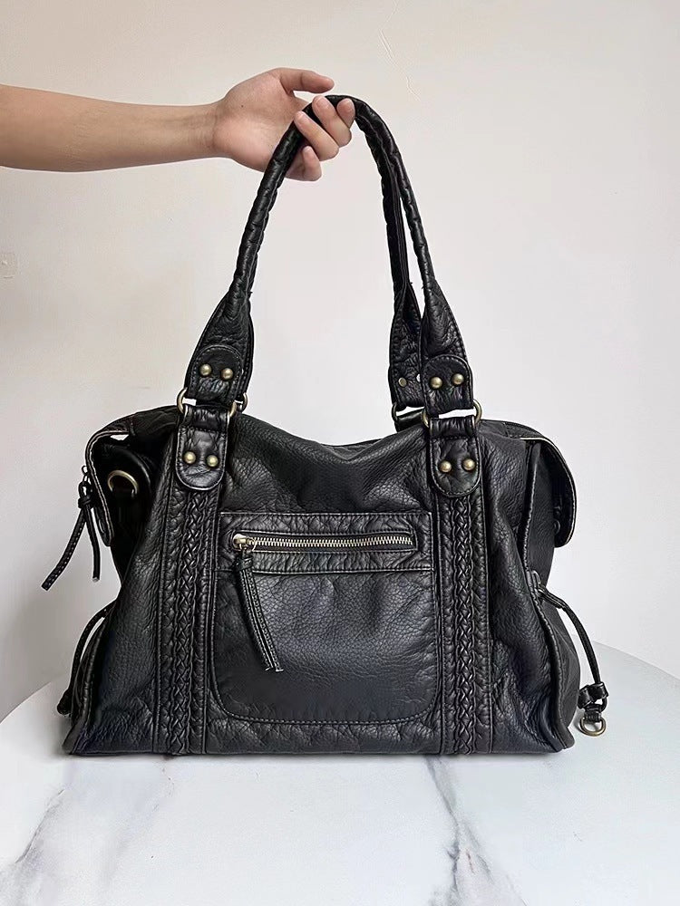Élégant sac à main vintage en cuir véritable noir pour femme, avec détails chic et bandoulière ajustable.