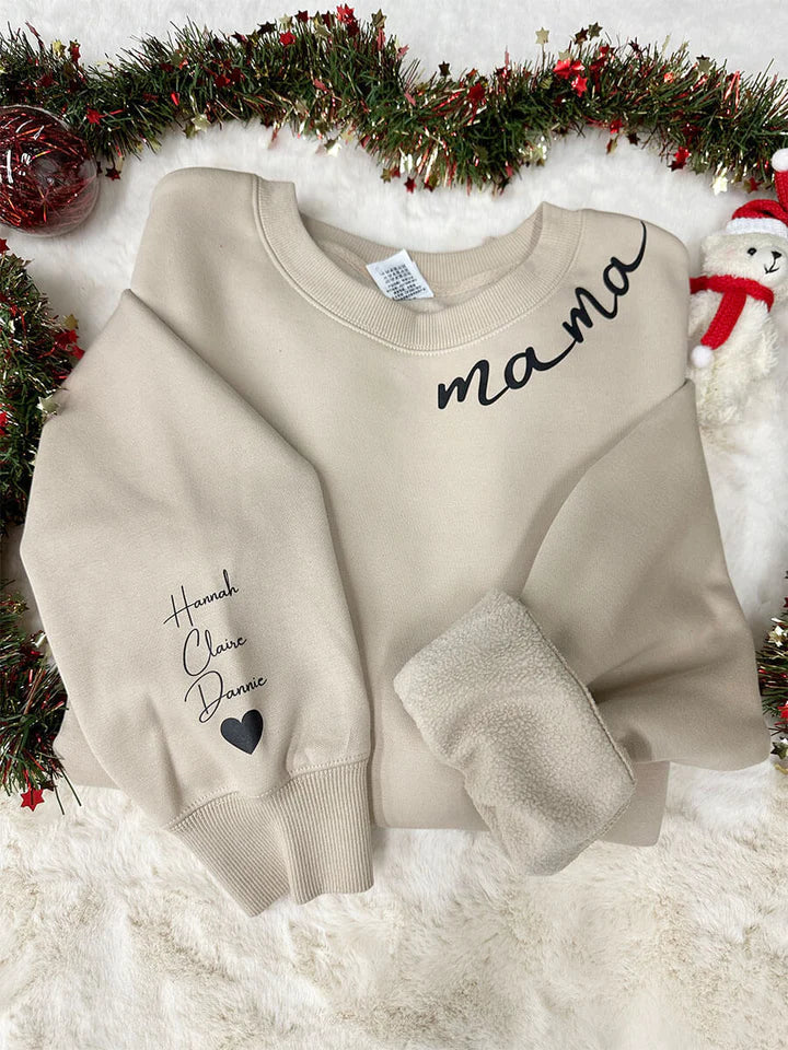 Détail: Noms des enfants gravés sur la manche d'un sweat à capuche personnalisé. Un cadeau touchant et unique pour parents.