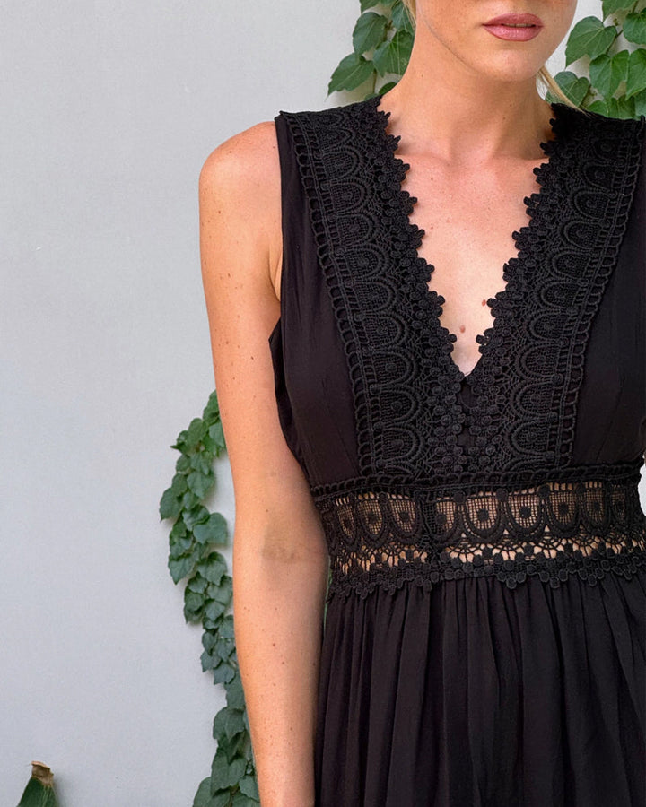 Robe midi femme avec col V et sans manches, coupe fluide, élégante et estivale.