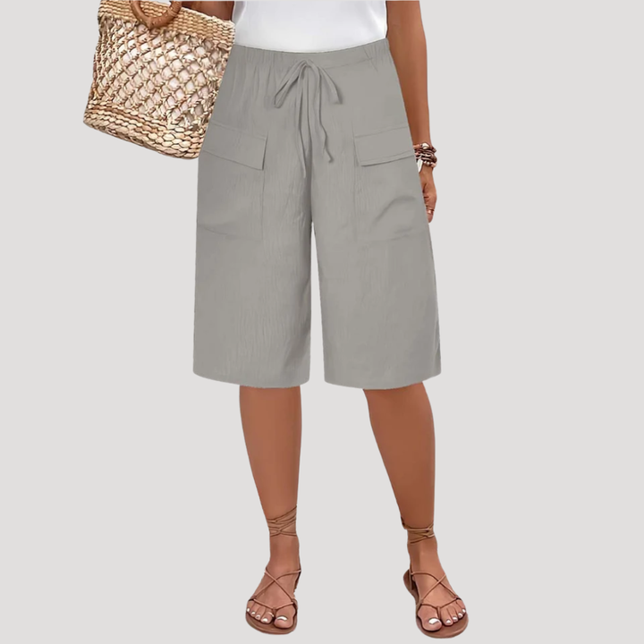 Bermuda femme longue avec taille élastique et poches, idéal pour confort et style décontracté d'été.