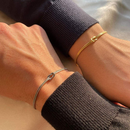 Bracelet argenté avec nœud, design moderne, élégance discrète pour le poignet.