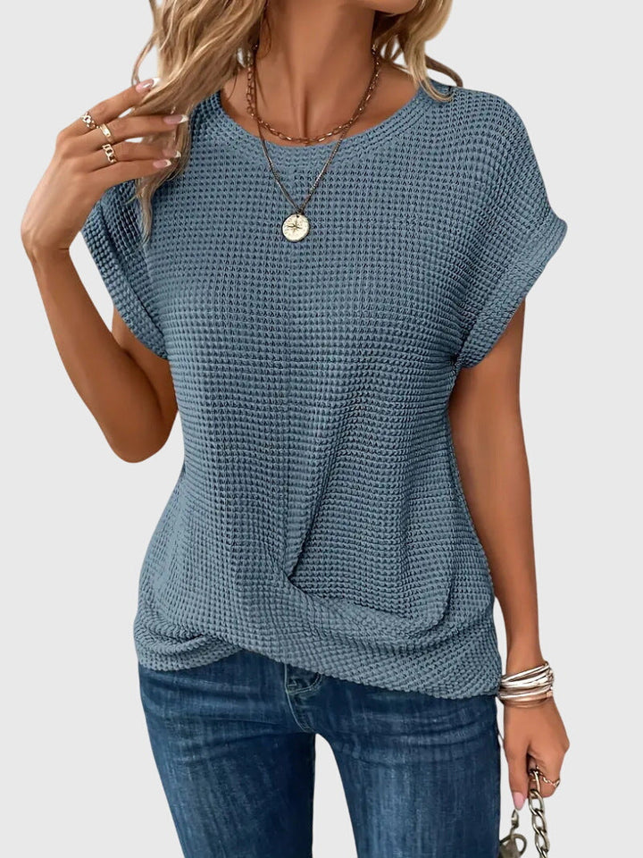 Blouse fluide femme à col rond, vêtement élégant et moderne pour un style professionnel ou casual chic.