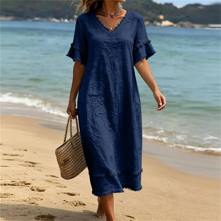 Robe fluide femme avec franges délicates et col V. Esprit bohème parfait pour les vacances ou les journées d'été.