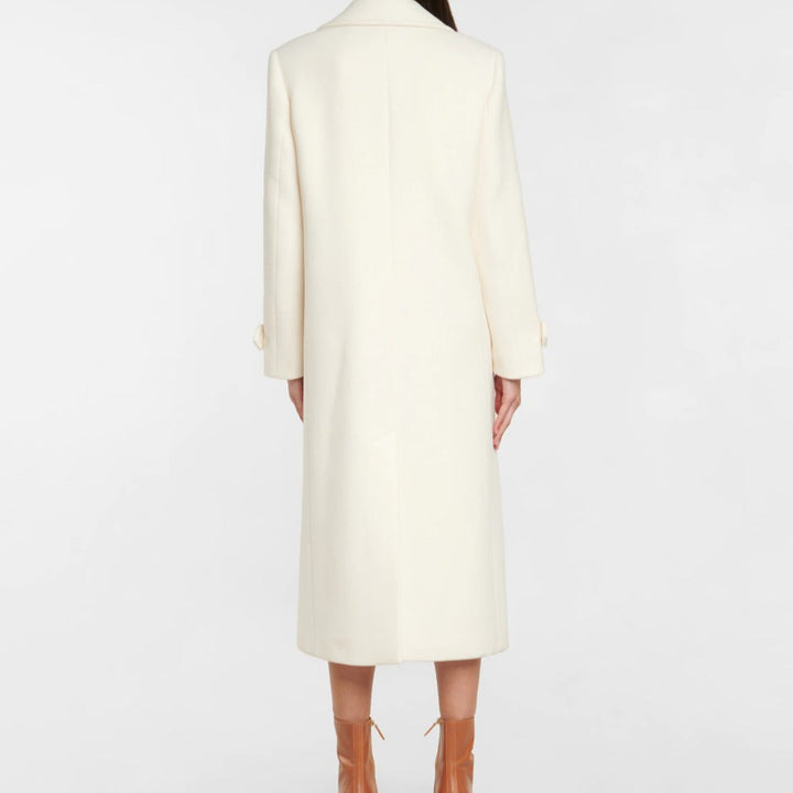 Femme portant un manteau long croisé élégant. Style chic pour l'automne et l'hiver. Vêtement extérieur tendance.