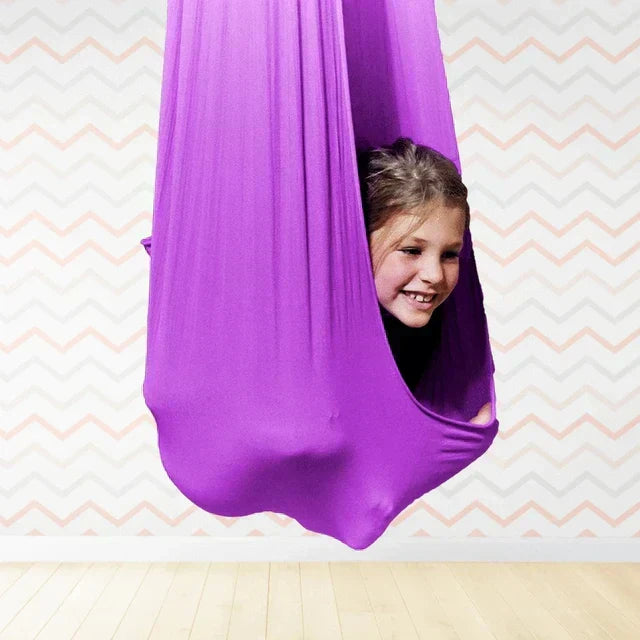 Cocon balançoire rouge en polyester pour enfant, offrant confort et douceur, pour usage intérieur/extérieur.