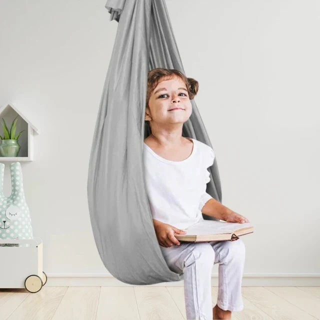 Balançoire hamac enfant gris, confortable et suspendue, parfaite pour jeu et détente intérieur/extérieur.