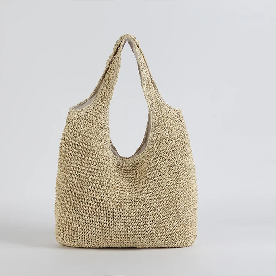 Grand sac de plage en paille pour femme, idéal comme tote bag d'été. Accessoire mode chic pour les vacances.
