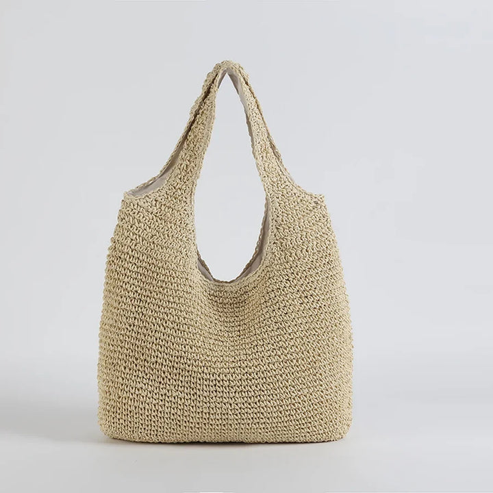Grand sac de plage en paille pour femme, idéal comme tote bag d'été. Accessoire mode chic pour les vacances.