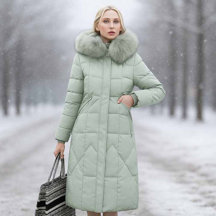 Silhouette féminine en manteau long matelassé, avec capuche, pièce maîtresse pour l'hiver.