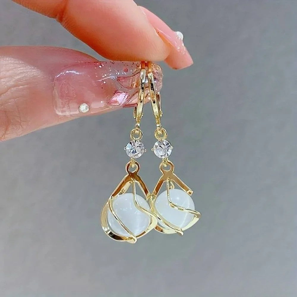 Boucles d'oreilles pendantes femme élégantes avec opale irisée et finition or antique, parfaites pour un look sophistiqué.
