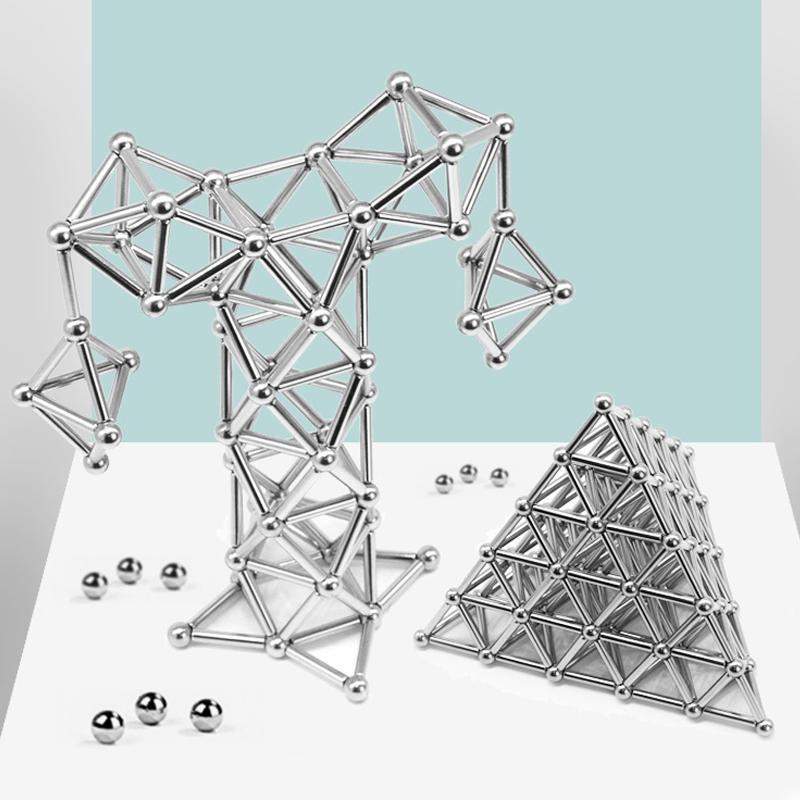 Enfant construisant une structure avec des blocs magnétiques, développant la motricité fine.