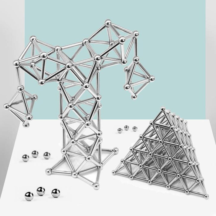 Enfant construisant une structure avec des blocs magnétiques, développant la motricité fine.