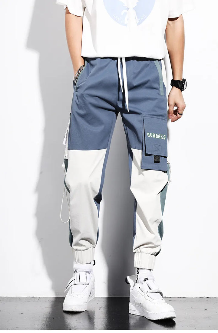 Jogger cargo bicolore bleu homme, coupe décontractée. Pantalon streetwear multi-poches, confortable.