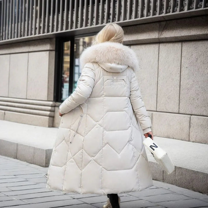 Femme portant un manteau matelassé long avec capuche, marchant en ville l'hiver, au chaud et stylée.
