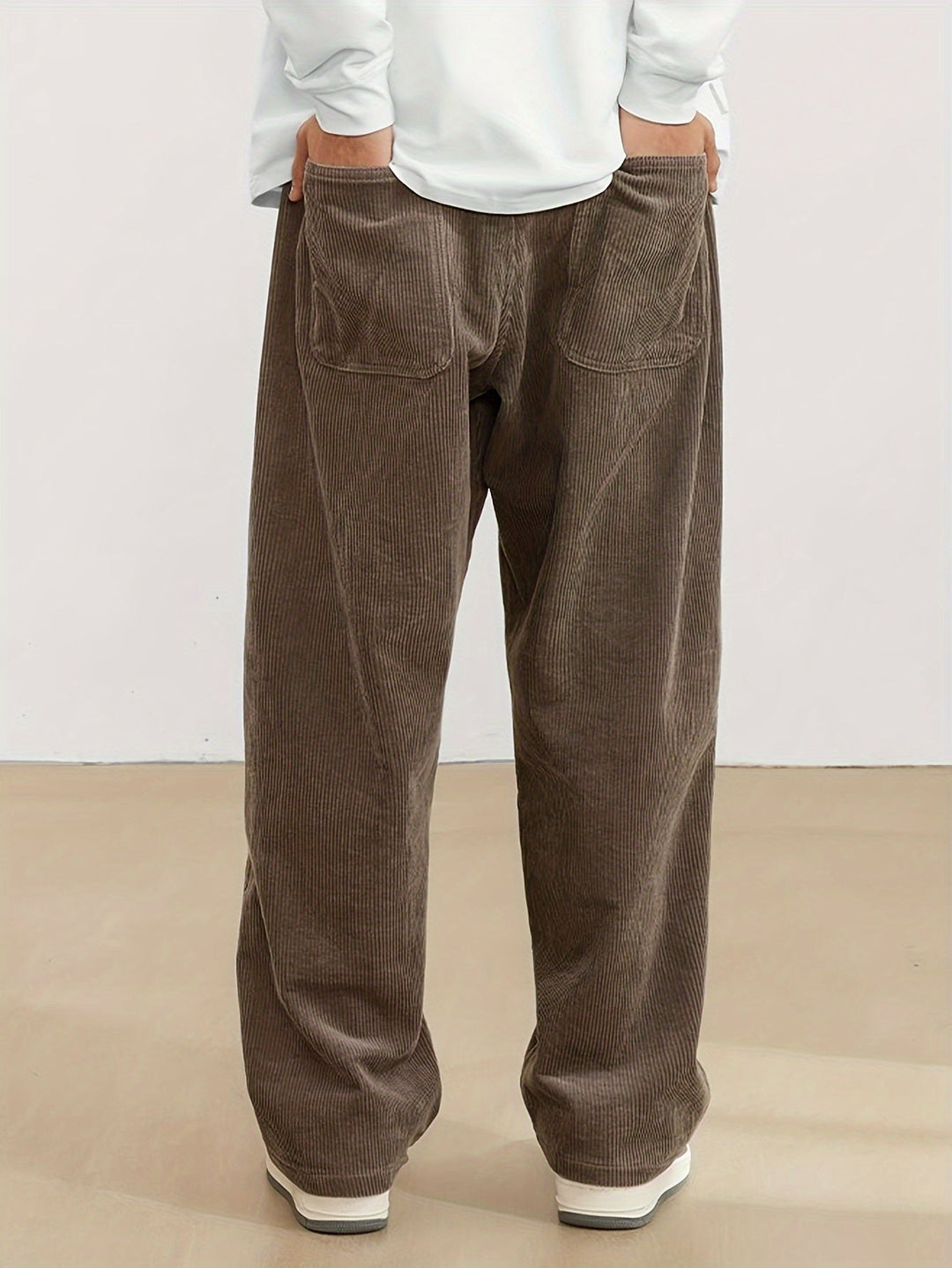 Pantalon homme velours côtelé, coupe jambes larges, style rétro, essentiel pour la mode masculine.