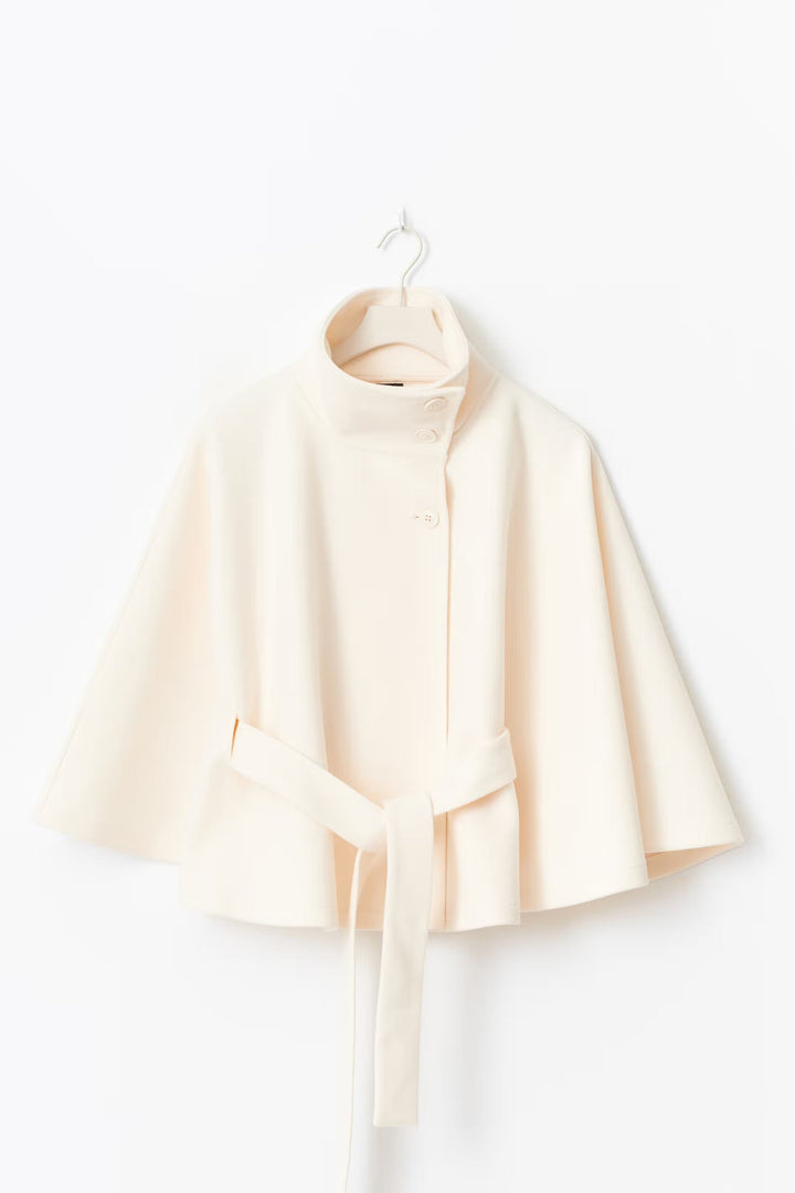 Détail du col haut du manteau femme, protégeant du froid, style chic et tendance mode hiver.