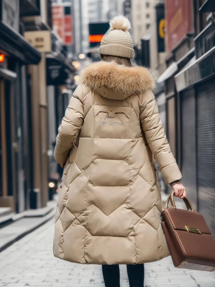 Veste d'hiver matelassée longue et chaude pour femme, avec capuche pour un confort optimal.