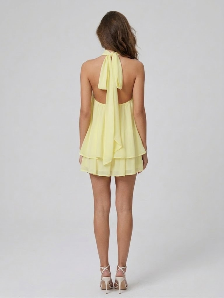 Robe femme estivale chic, dos nu, col halter, coupe courte et volantée. Un incontournable de l'été.