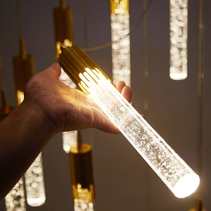 Élégante lampe à suspension en verre, forme cylindrique, pour un éclairage design et doux.