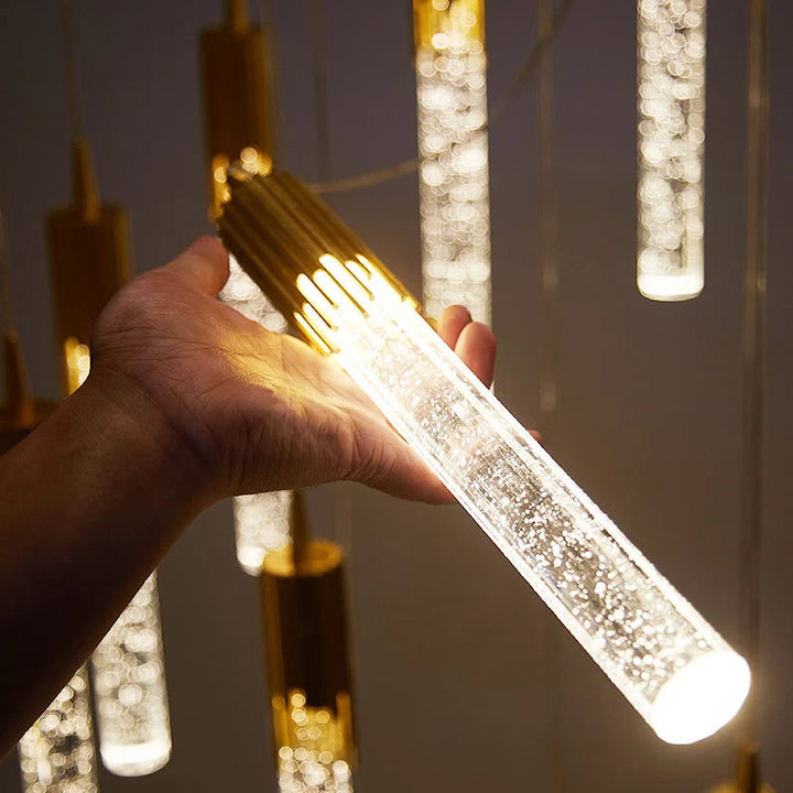 Élégante lampe à suspension en verre, forme cylindrique, pour un éclairage design et doux.