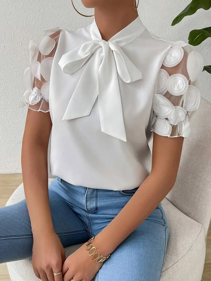 Blouse femme moderne et chic à nœud, manches transparentes. Idéale pour un look bureau ou soirée sophistiqué.